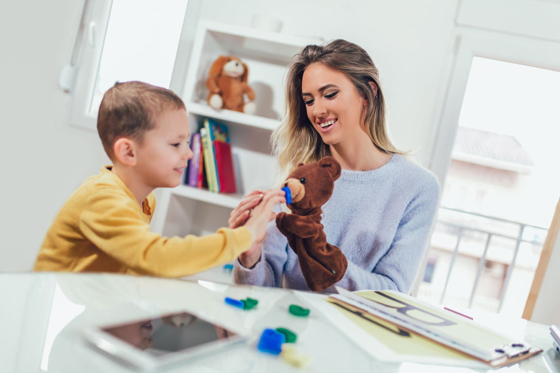 Little boy during lesson with his speech therapist.